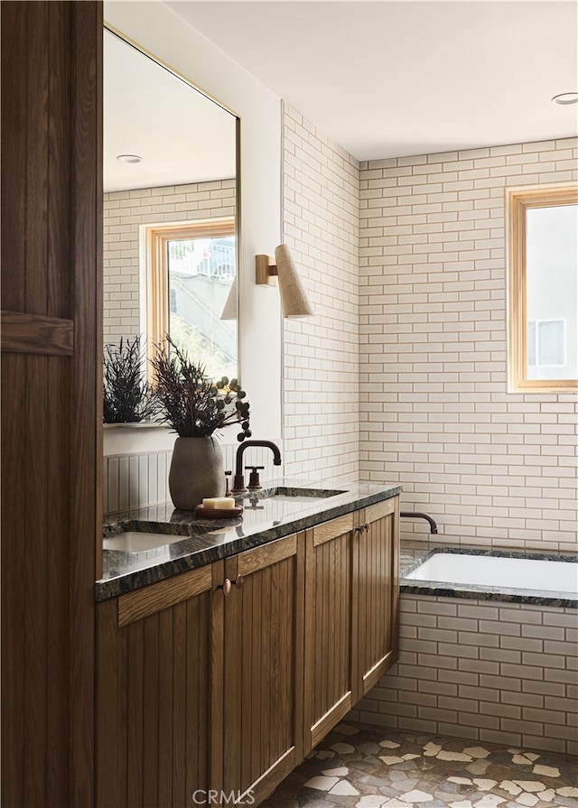 bathroom with a relaxing tiled tub and vanity