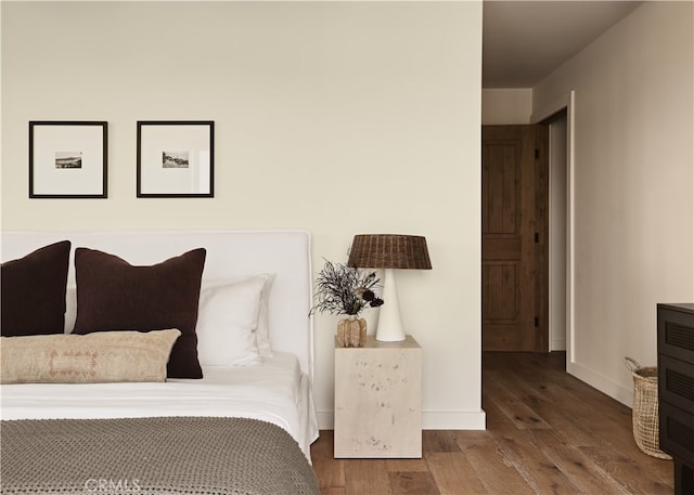 bedroom featuring hardwood / wood-style floors and baseboards