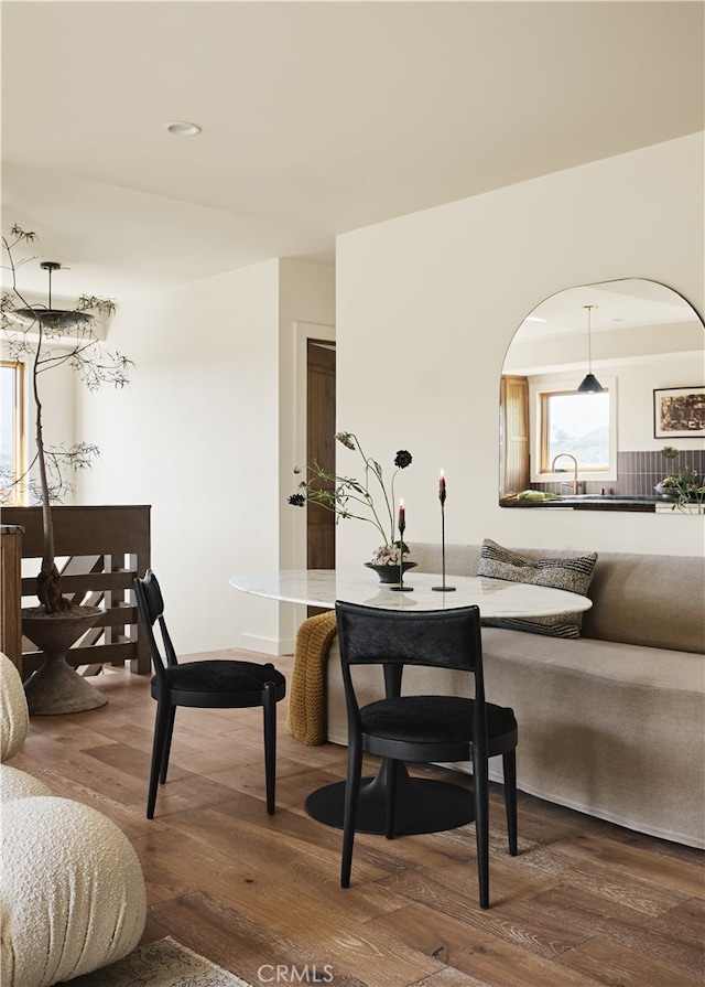 living room featuring wood finished floors, arched walkways, and recessed lighting