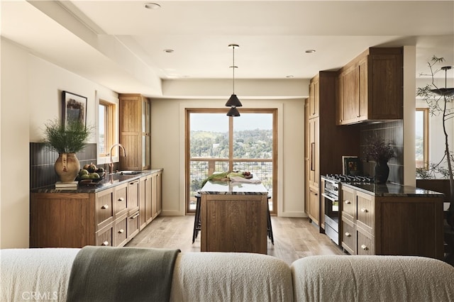 kitchen featuring a sink, light wood-type flooring, oven, baseboards, and recessed lighting