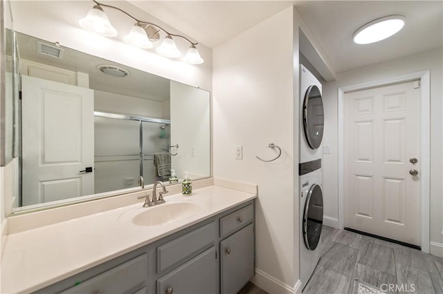 1263 Sandra Ct, Upland, CA 91786 - bathroom with stacked washing machine and dryer, baseboards, vanity, and a shower with door