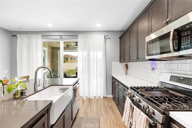 24521 Snapdragon Way, Lake Elsinore, CA 92532 - kitchen with appliances with stainless steel finishes, a sink, dark brown cabinets, light wood finished floors, and tasteful backsplash