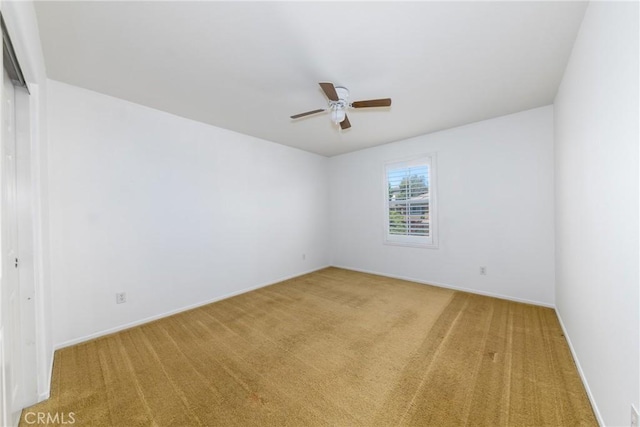 unfurnished room with carpet flooring, a ceiling fan, and baseboards