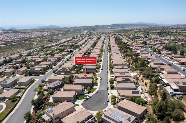 aerial view of property and surrounding area with nearby suburban area and a mountainous background