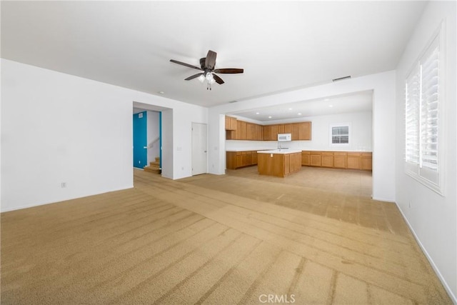 unfurnished living room with light colored carpet, a ceiling fan, recessed lighting, and baseboards
