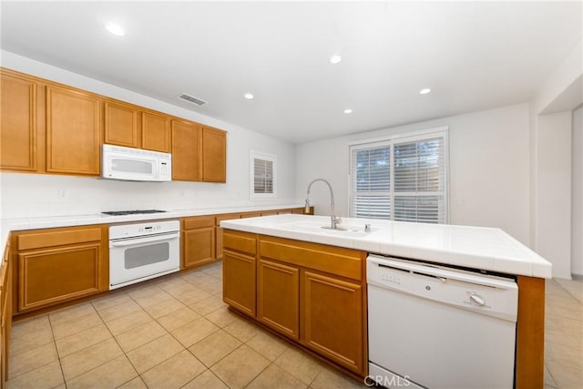kitchen featuring white appliances, a sink, light tile patterned floors, tile countertops, and recessed lighting