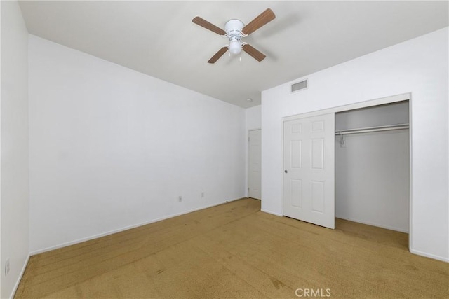 unfurnished bedroom with carpet flooring, a closet, and a ceiling fan