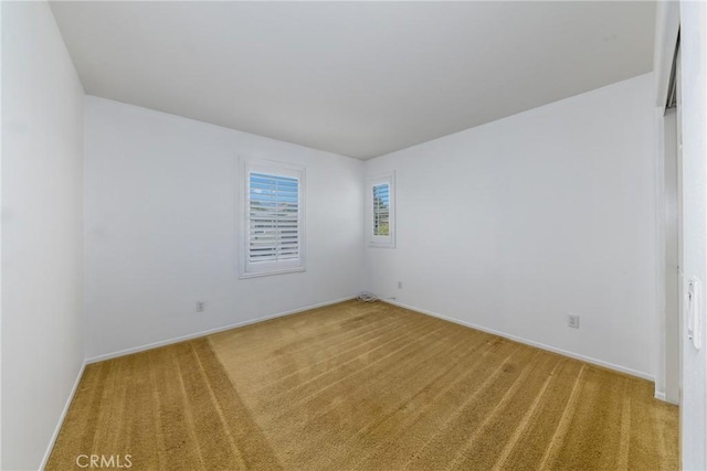 carpeted spare room with baseboards
