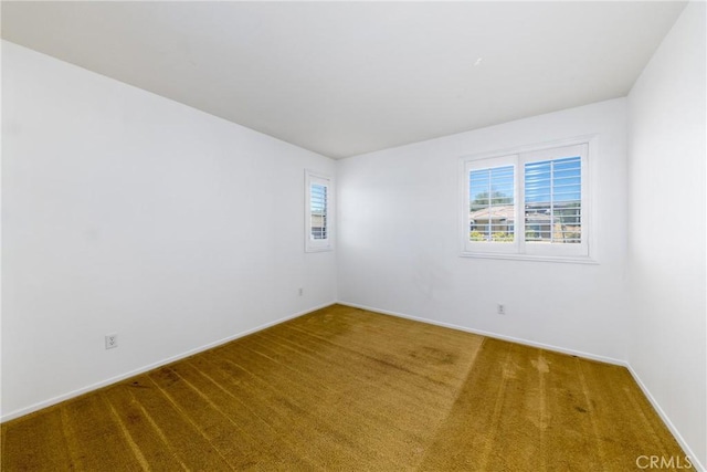 carpeted empty room with baseboards