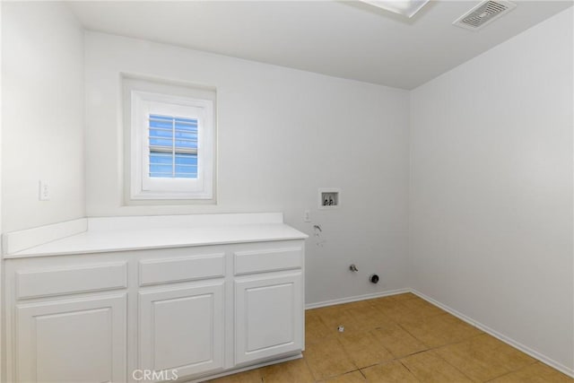 washroom with hookup for a gas dryer, washer hookup, light tile patterned floors, baseboards, and cabinet space
