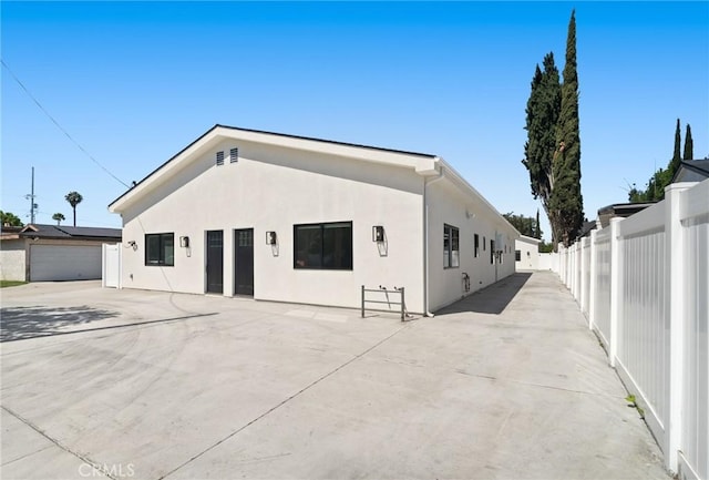 view of front facade with fence and stucco siding