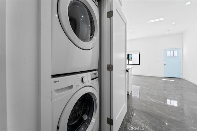 laundry room with stacked washer / drying machine, marble tiled flooring, baseboards, and recessed lighting