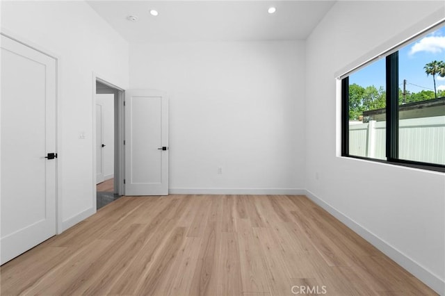spare room with light wood-style flooring, recessed lighting, and baseboards