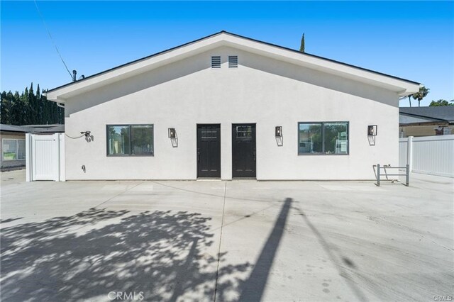 back of house featuring stucco siding, fence, and a patio area