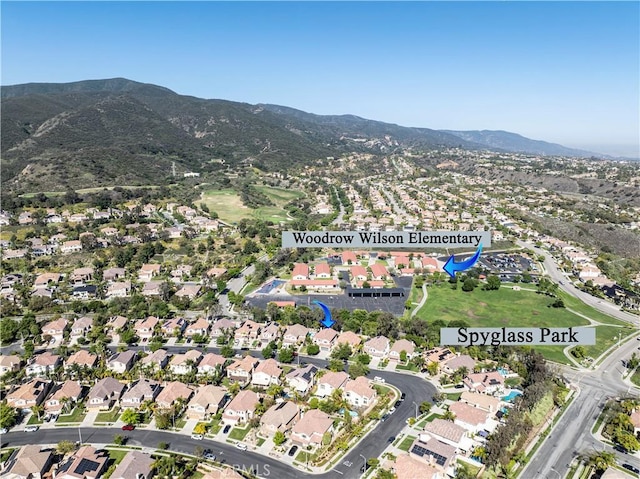 aerial view of property's location with a mountainous background and nearby suburban area