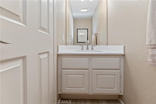 bathroom with vanity and a textured wall