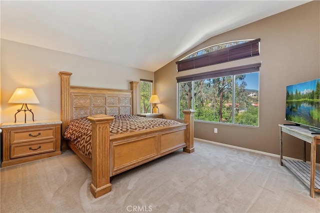 bedroom featuring vaulted ceiling, light carpet, multiple windows, and baseboards