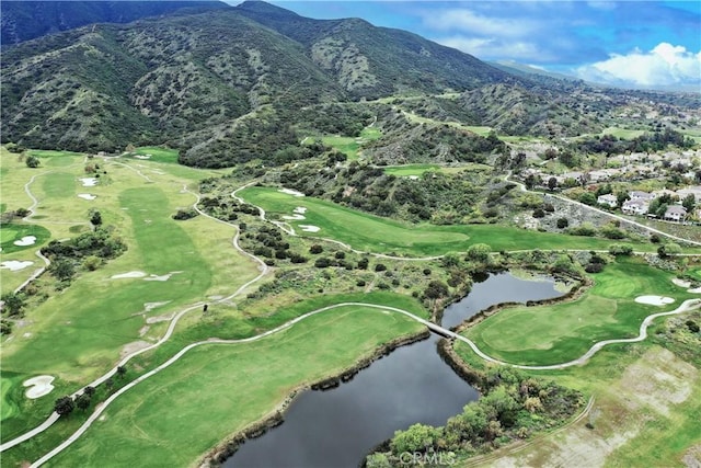 drone / aerial view of a water and mountain view and a local golf course