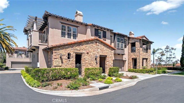 view of front facade with a chimney, stucco siding, and stone siding