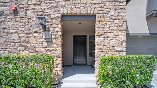 property entrance with stone siding and stucco siding