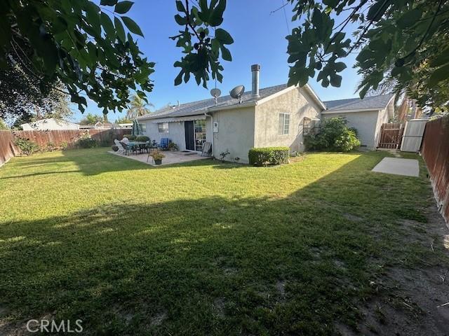back of property featuring stucco siding, a patio area, and a gate