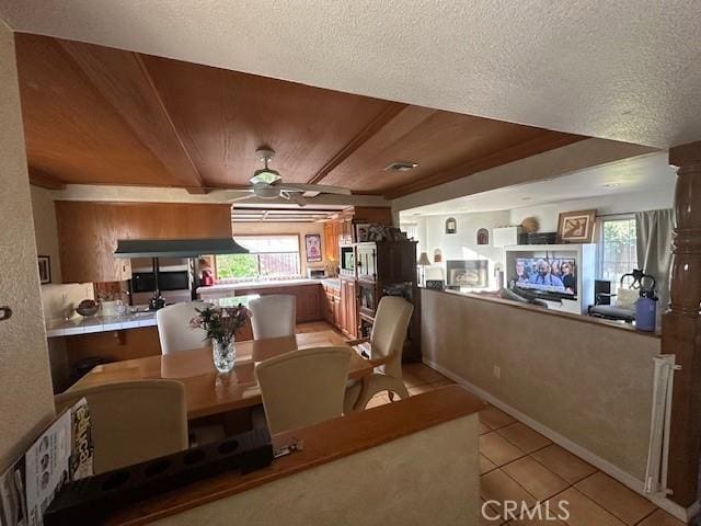 dining room featuring a ceiling fan, light tile patterned floors, a textured ceiling, wood ceiling, and baseboards