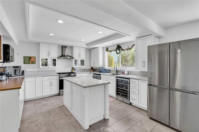 33645 Kobe Rd, Agua Dulce, CA 91390 - kitchen featuring appliances with stainless steel finishes, beverage cooler, a tray ceiling, wall chimney range hood, and recessed lighting
