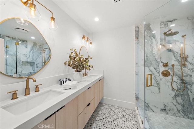bathroom with a marble finish shower, baseboards, recessed lighting, and double vanity