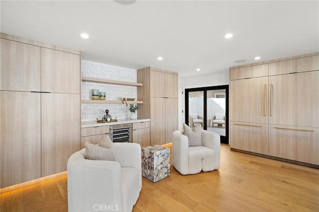 living room with wet bar, wine cooler, light wood-type flooring, and recessed lighting