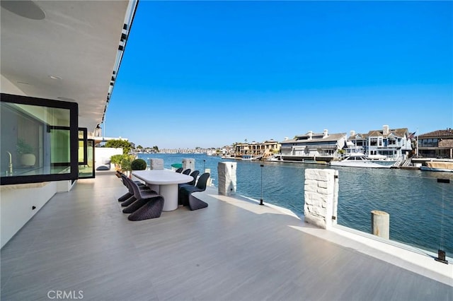 dock with a water view and outdoor dining space
