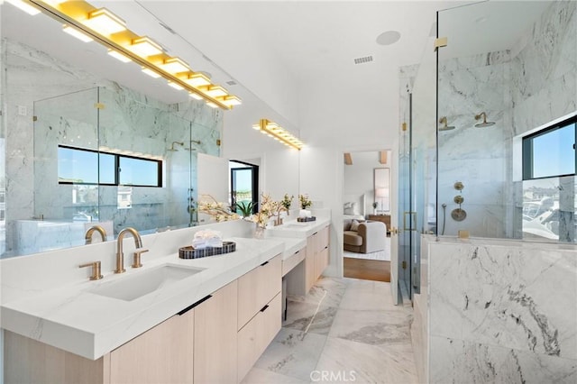 full bath featuring a marble finish shower, marble tiled floors, vanity, and ensuite bath