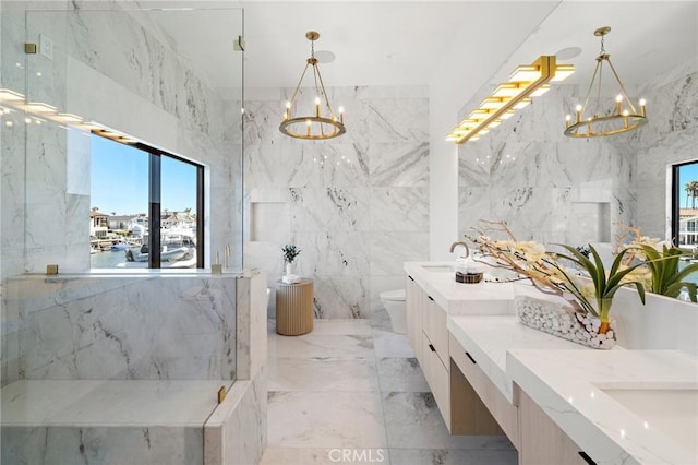 bathroom with a chandelier, double vanity, toilet, tile walls, and marble tiled floors