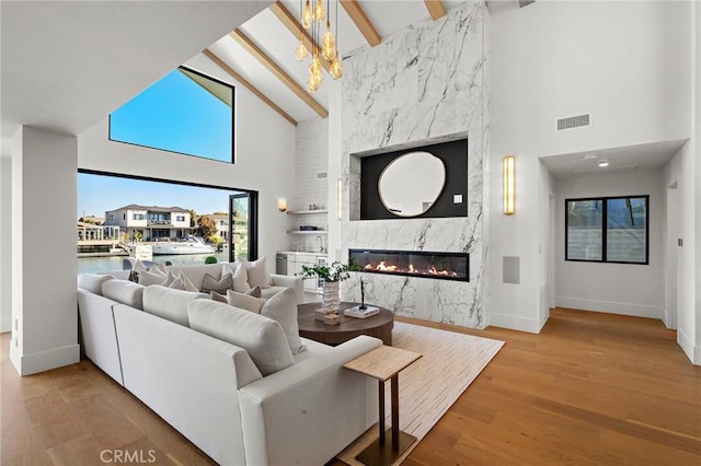 living room with high vaulted ceiling, baseboards, a fireplace, healthy amount of natural light, and beam ceiling