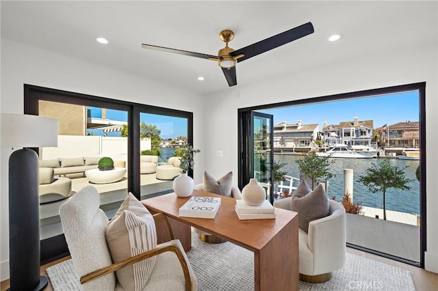 dining area with wood finished floors, ceiling fan, recessed lighting, and a water view