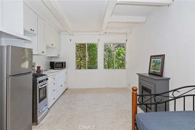 323 Mittry Ln, Lake Arrowhead, CA 92352 - kitchen with appliances with stainless steel finishes, beam ceiling, light carpet, white cabinets, and light countertops