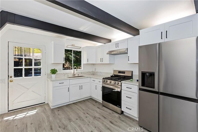 323 Mittry Ln, Lake Arrowhead, CA 92352 - kitchen with stainless steel appliances, a sink, under cabinet range hood, light wood-style floors, and beam ceiling