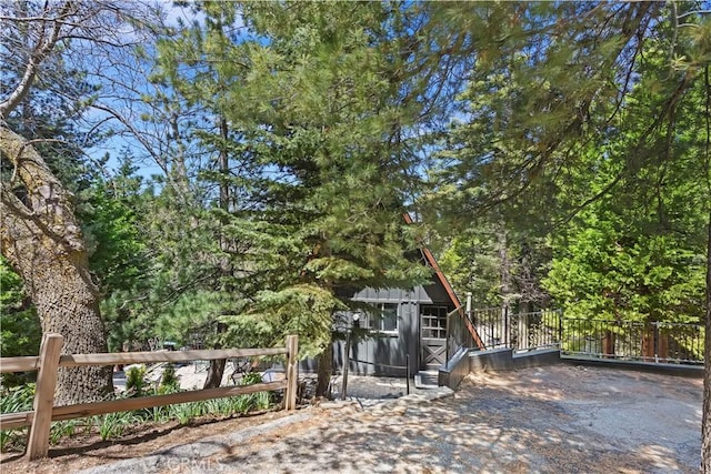 323 Mittry Ln, Lake Arrowhead, CA 92352 - gate featuring an outdoor structure, a storage shed, fence, and a forest view