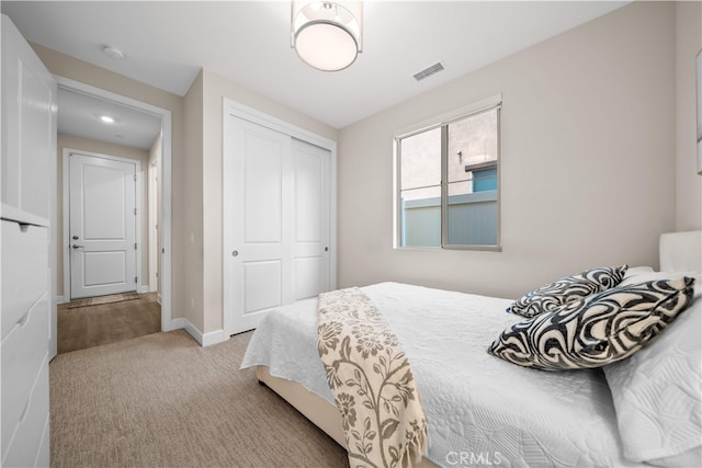 carpeted bedroom featuring a closet and baseboards