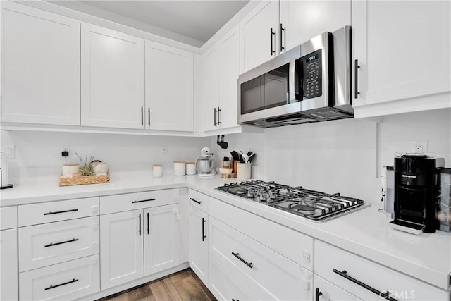 16708 Yarrow Ln, Fontana, CA 92336 - kitchen featuring stainless steel appliances, light countertops, white cabinetry, and wood finished floors