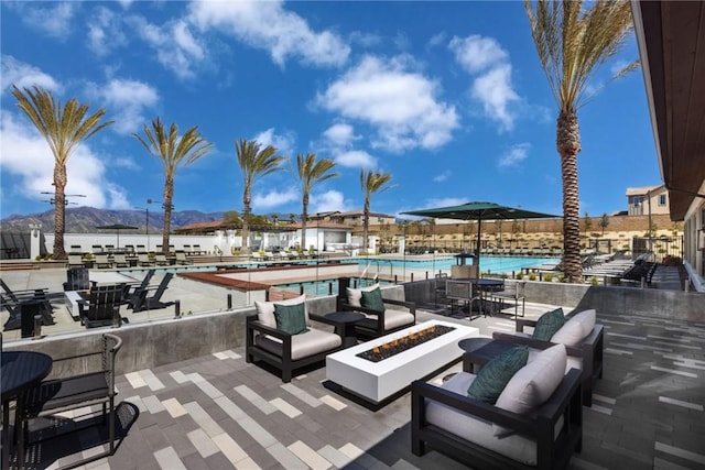 16708 Yarrow Ln, Fontana, CA 92336 - view of patio with a mountain view, a community pool, and an outdoor living space with a fire pit