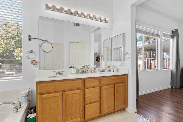 11556 Caldy Ave, Loma Linda, CA 92354 - bathroom featuring double vanity, wood finished floors, and a bath