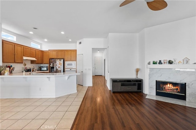 11556 Caldy Ave, Loma Linda, CA 92354 - kitchen featuring white microwave, stainless steel fridge with ice dispenser, a peninsula, a kitchen breakfast bar, and a ceiling fan