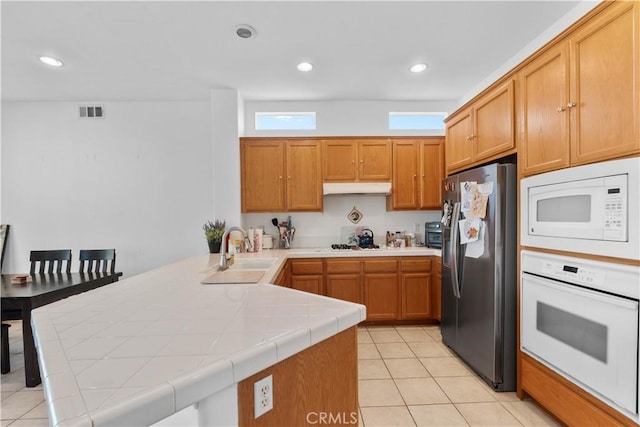 11556 Caldy Ave, Loma Linda, CA 92354 - kitchen with white appliances, a sink, under cabinet range hood, tile counters, and a peninsula
