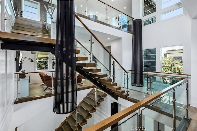 staircase with a high ceiling and healthy amount of natural light