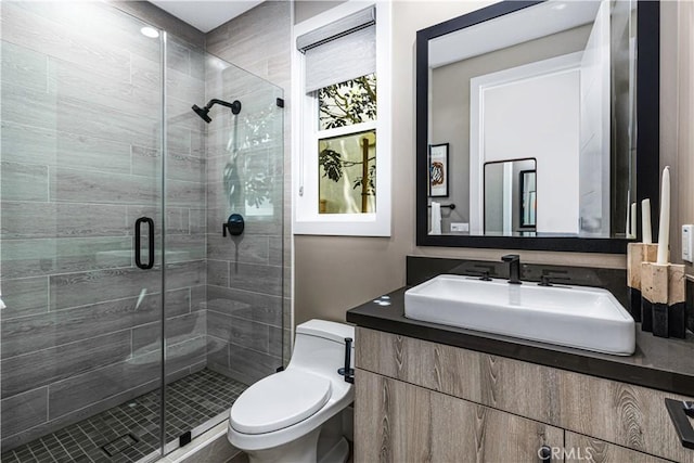 full bath with a shower stall, toilet, and vanity
