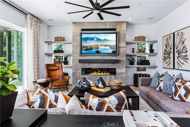 living room featuring a fireplace, a ceiling fan, wood finished floors, and recessed lighting