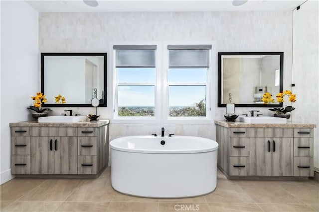 bathroom featuring two vanities and a freestanding bath