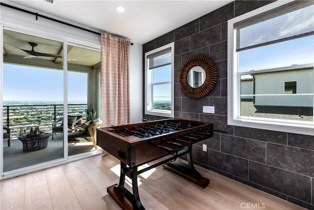 game room with wood finished floors, ceiling fan, tile walls, and recessed lighting