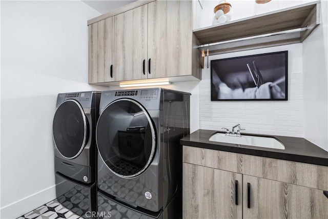 clothes washing area featuring washer and clothes dryer, cabinet space, and baseboards
