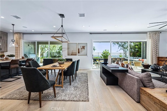 dining space with plenty of natural light, light wood-style flooring, and recessed lighting